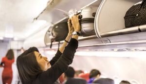 woman luggage carry-on overhead flight plane