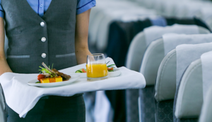 Flight attendant serving food onboard an airplane