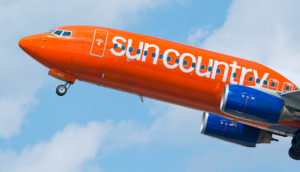 Sun country airplane taking off with logo on side of plane