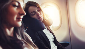 woman relaxing on airplane with neck pillow