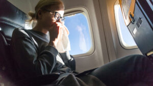blonde-caucasian-woman-sneezing-on-airplane