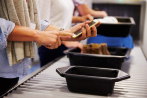 Man-checking-iphone-at-TSA-security-at-airport
