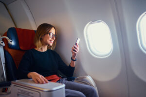 Woman in Business Class Checks Smartphone