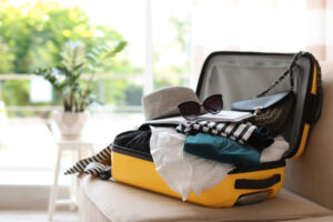 yellow suitcase overflowing with clothes