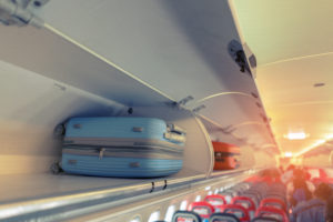 Carry-on luggage in overhead bin on airplane