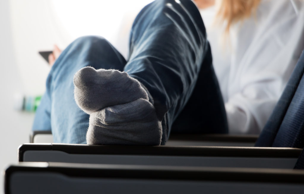 Woman with feet up on airplane seat