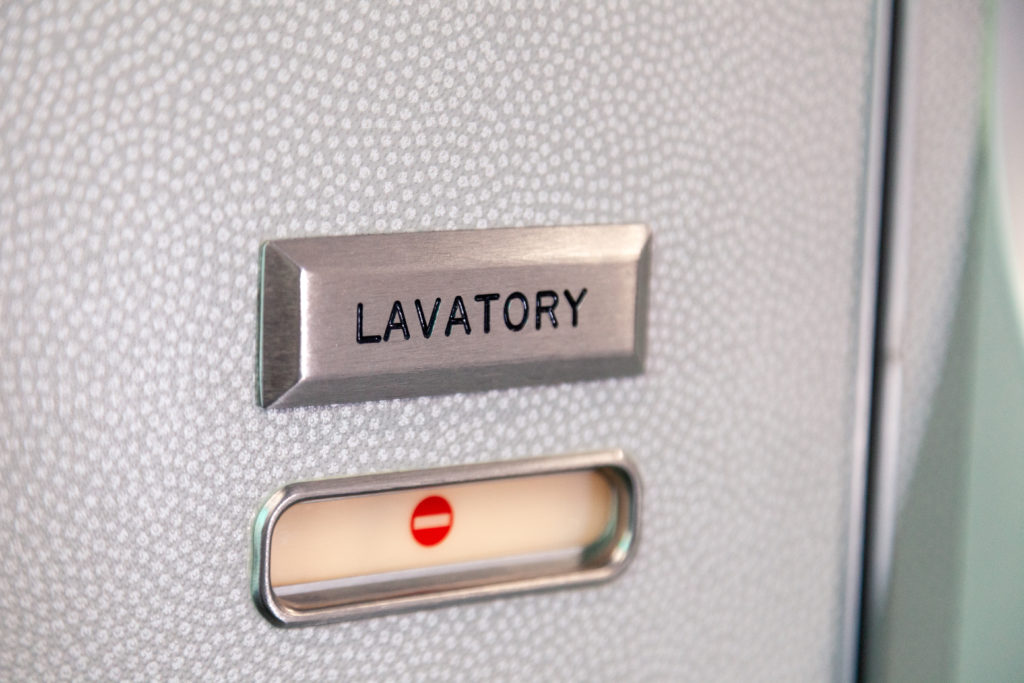 Airplane bathroom lock with red symbol indicating that the bathroom is occupied and locked