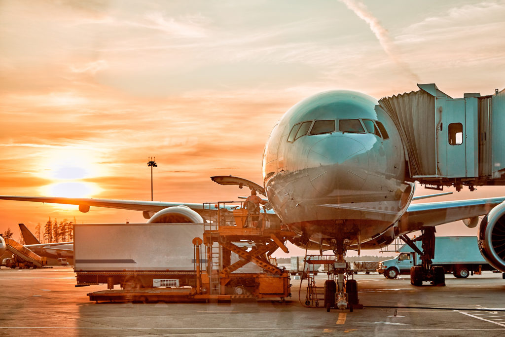 An airplane on the runway at sunset