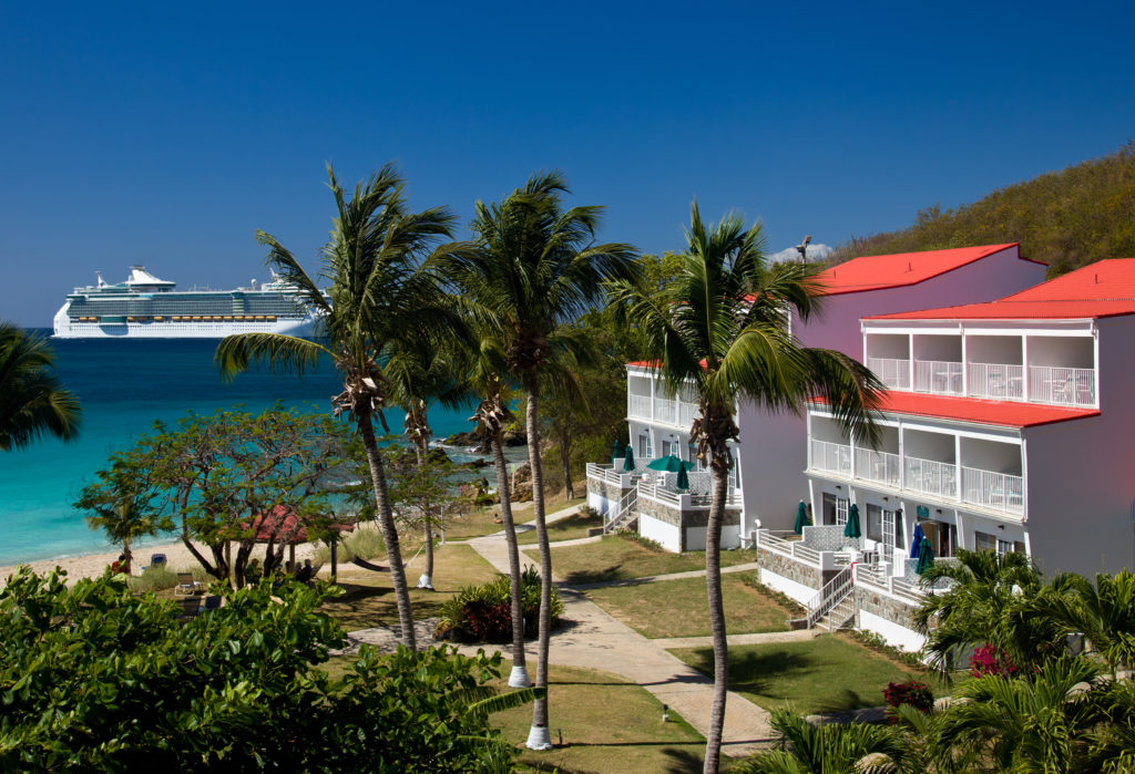 Resort in front of the ocean with a cruise ship in the background 