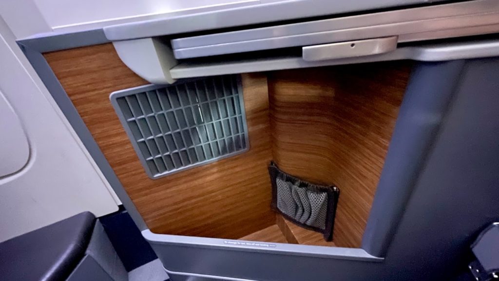 Storage center near plane seat in American Airlines business class cabin