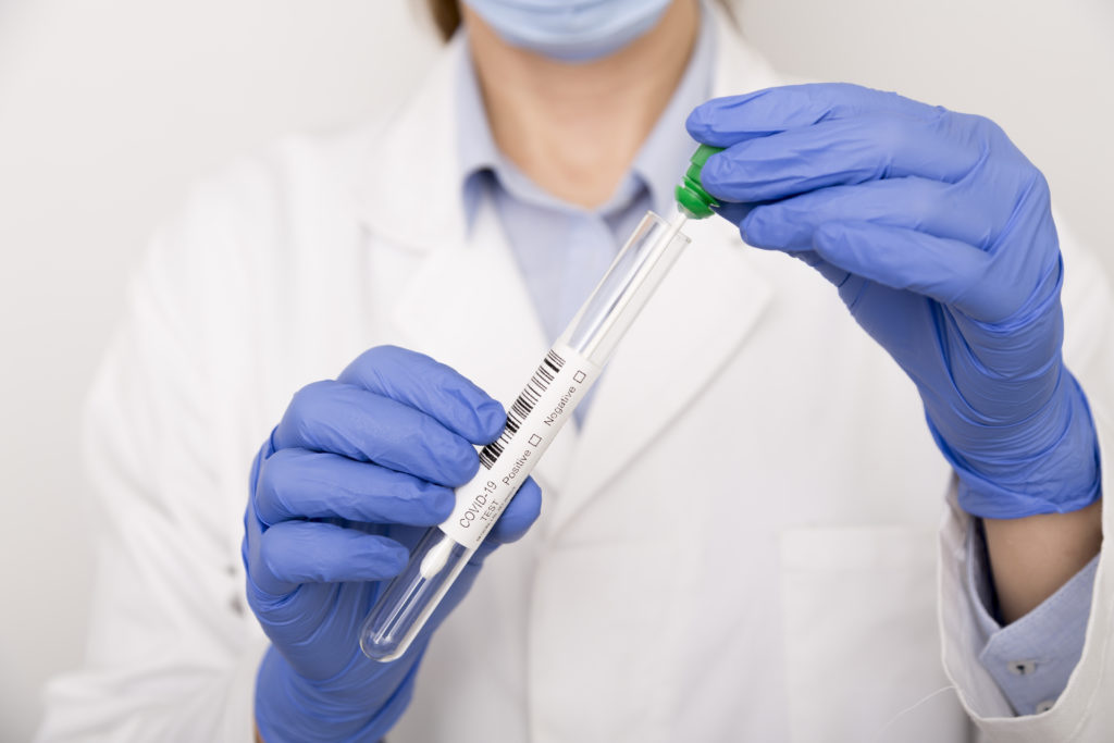 Nurse opening a COVID-19 test wearing blue gloves