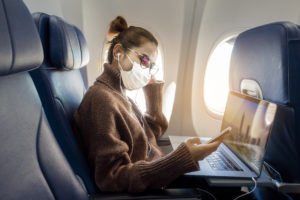 Woman wearing a face mask on an airplane