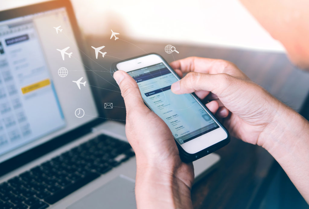 Person booking a flight on their laptop and phone