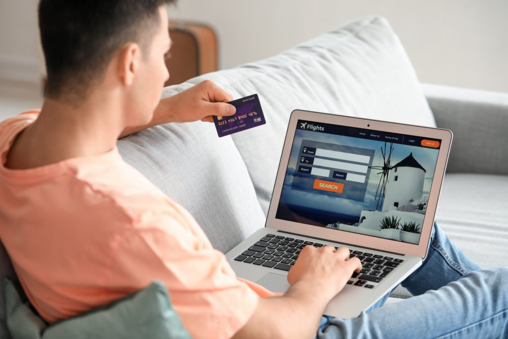 Man with laptop and credit card booking flight