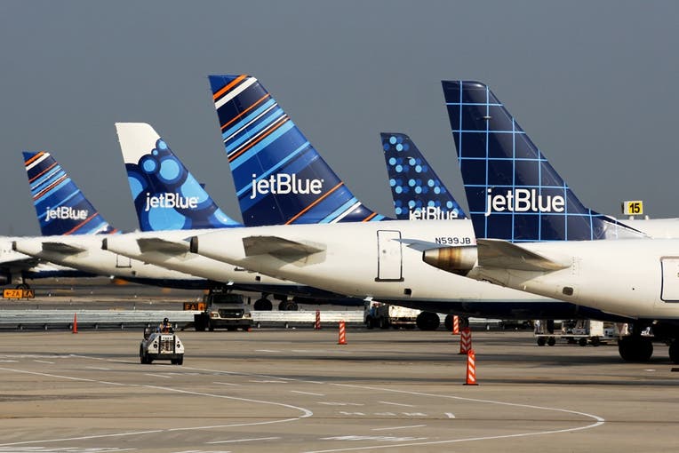 Several JetBlue planes parked on an airport tarmac