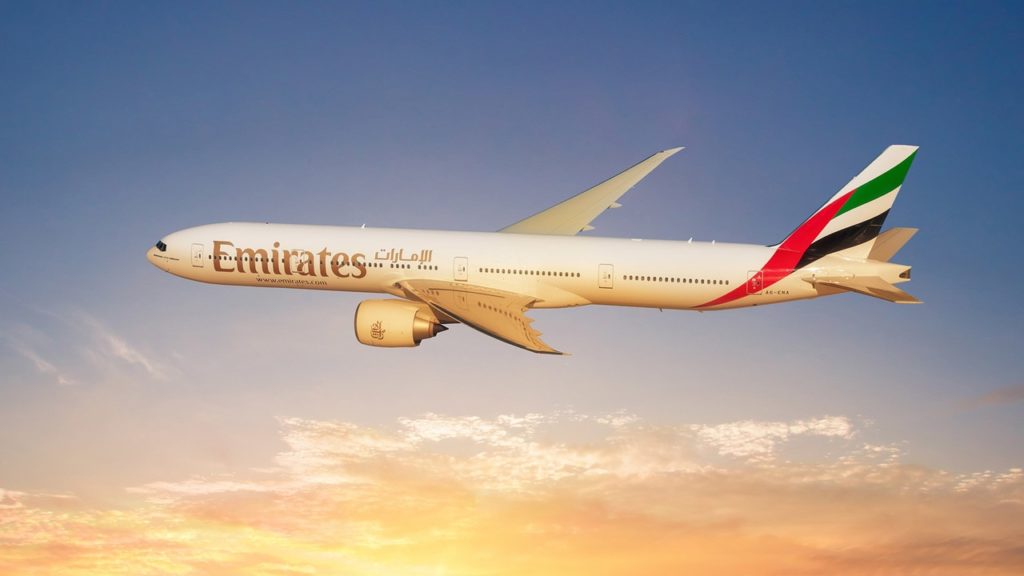 Emirates plane flying into sunset