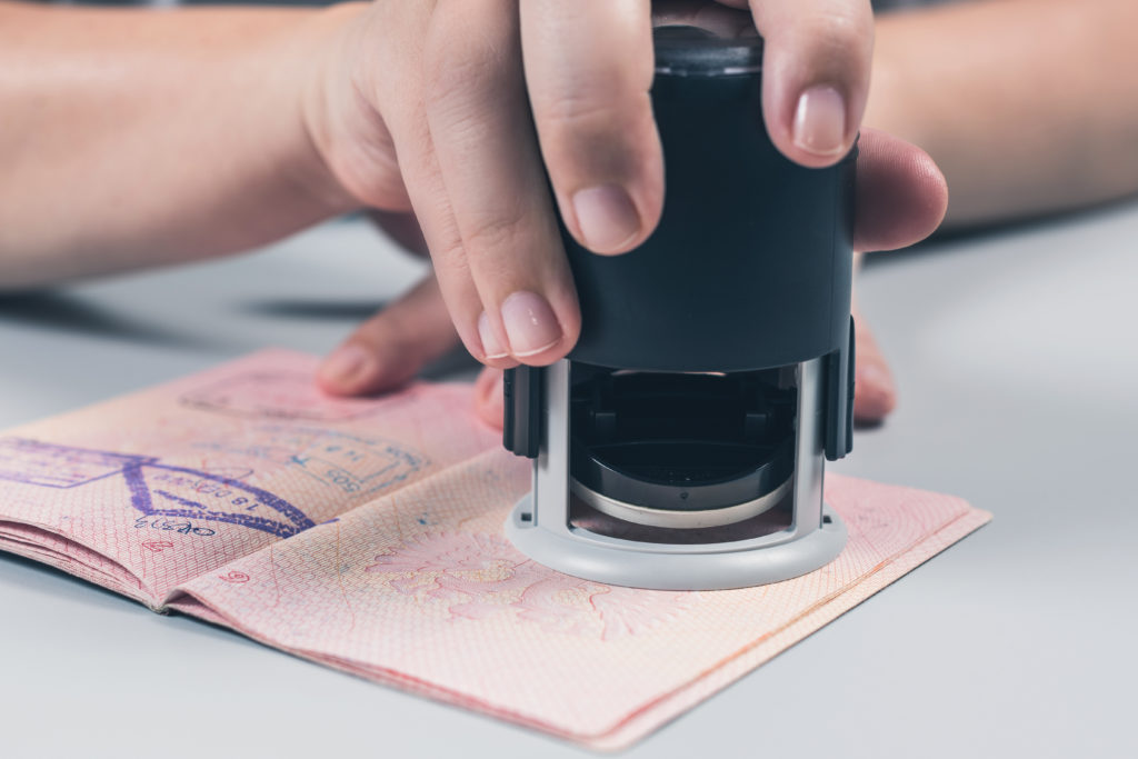 Close-up of hand stamping a passport