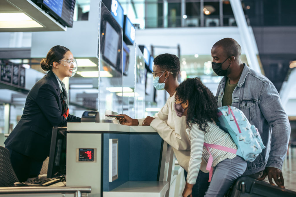Family speaking with ground staff at airport check in counter