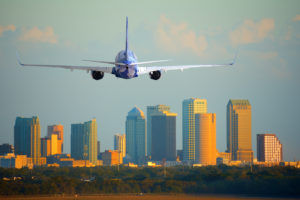 Airplane taking off with city skyline in the background