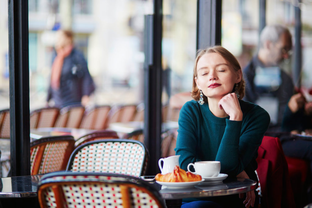 Woman drinking coffee alone in a cafe in Paris