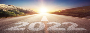 New Year's concept, a road leading into a distant sunrise with 2022 printed on the pavement
