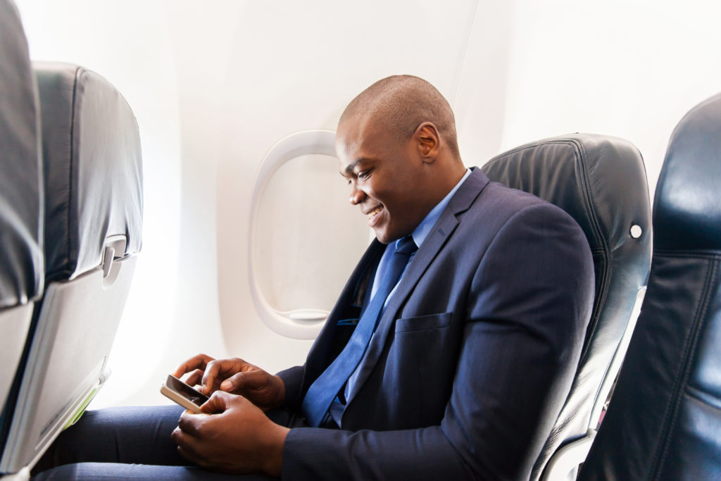 Man texting on airplane